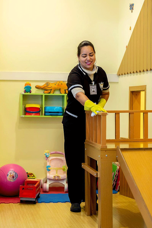 Profissional realizando limpeza de playground em condomínio